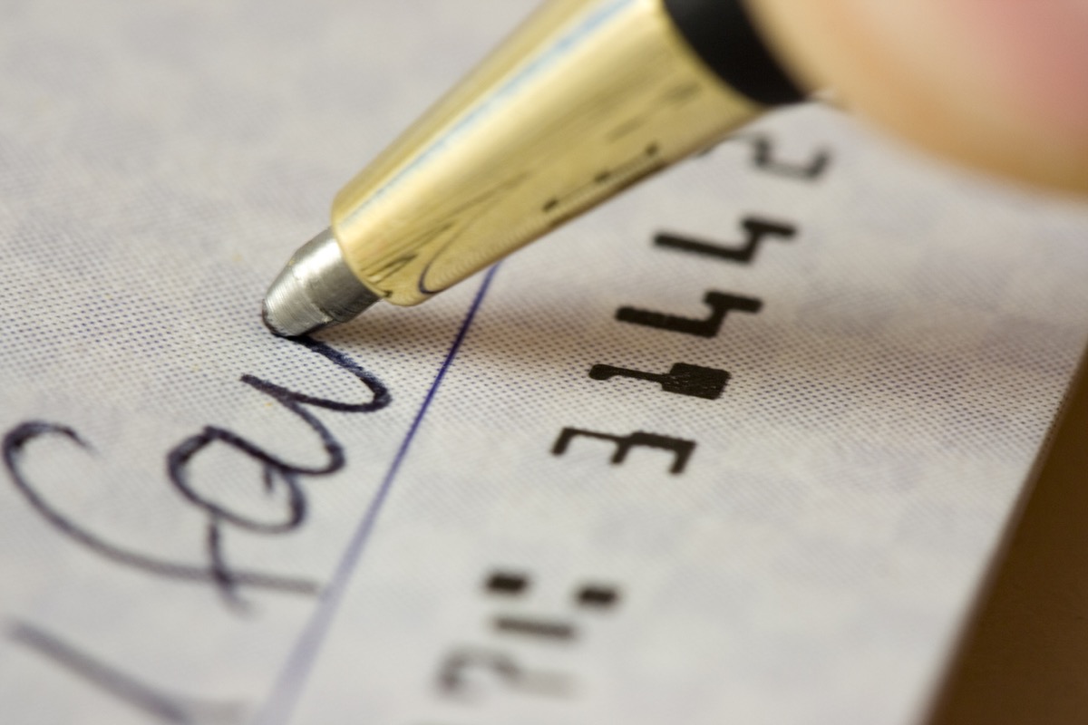 close up of someone signing a check