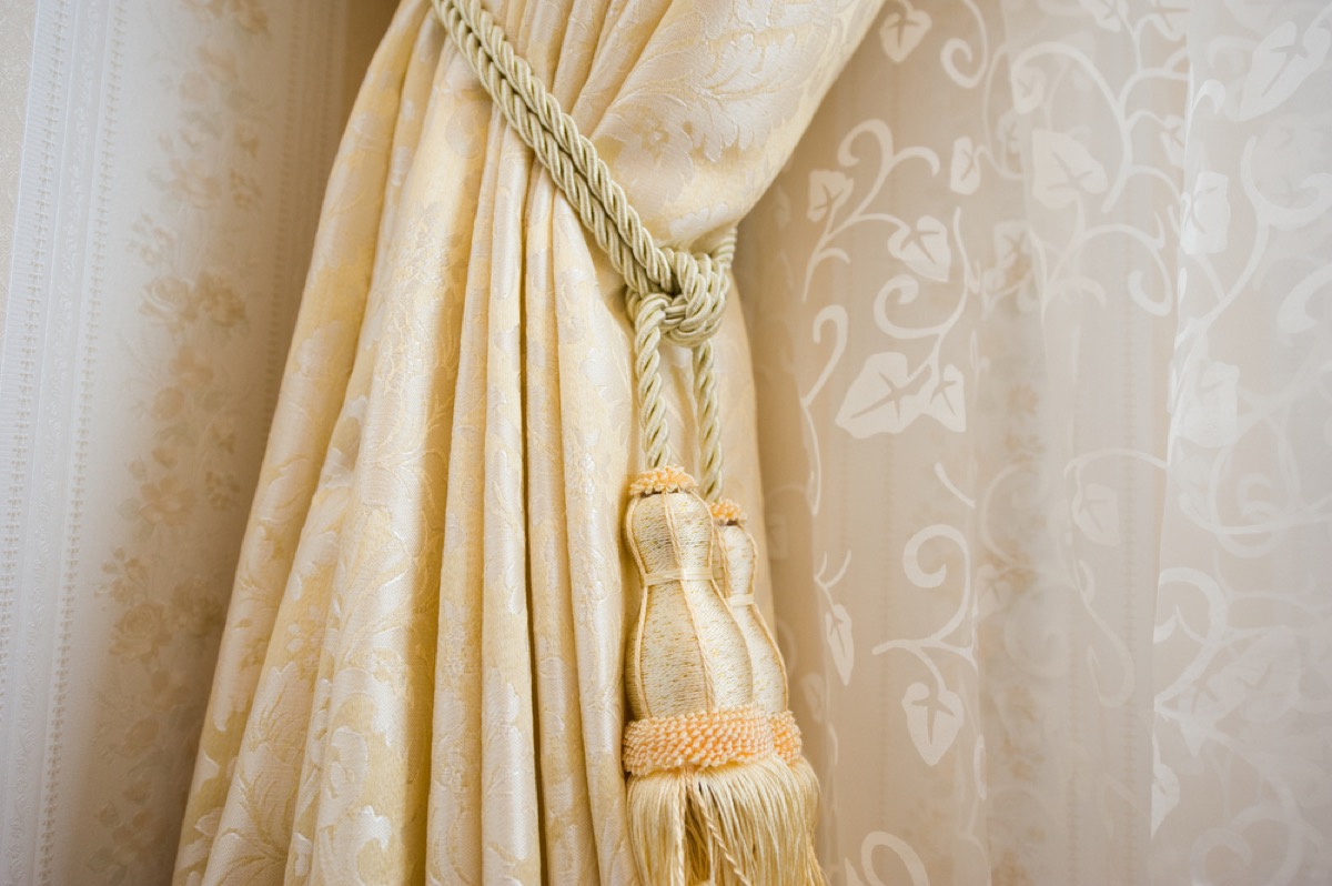 fancy yellow curtain with tassel tieback, fire prevention tips