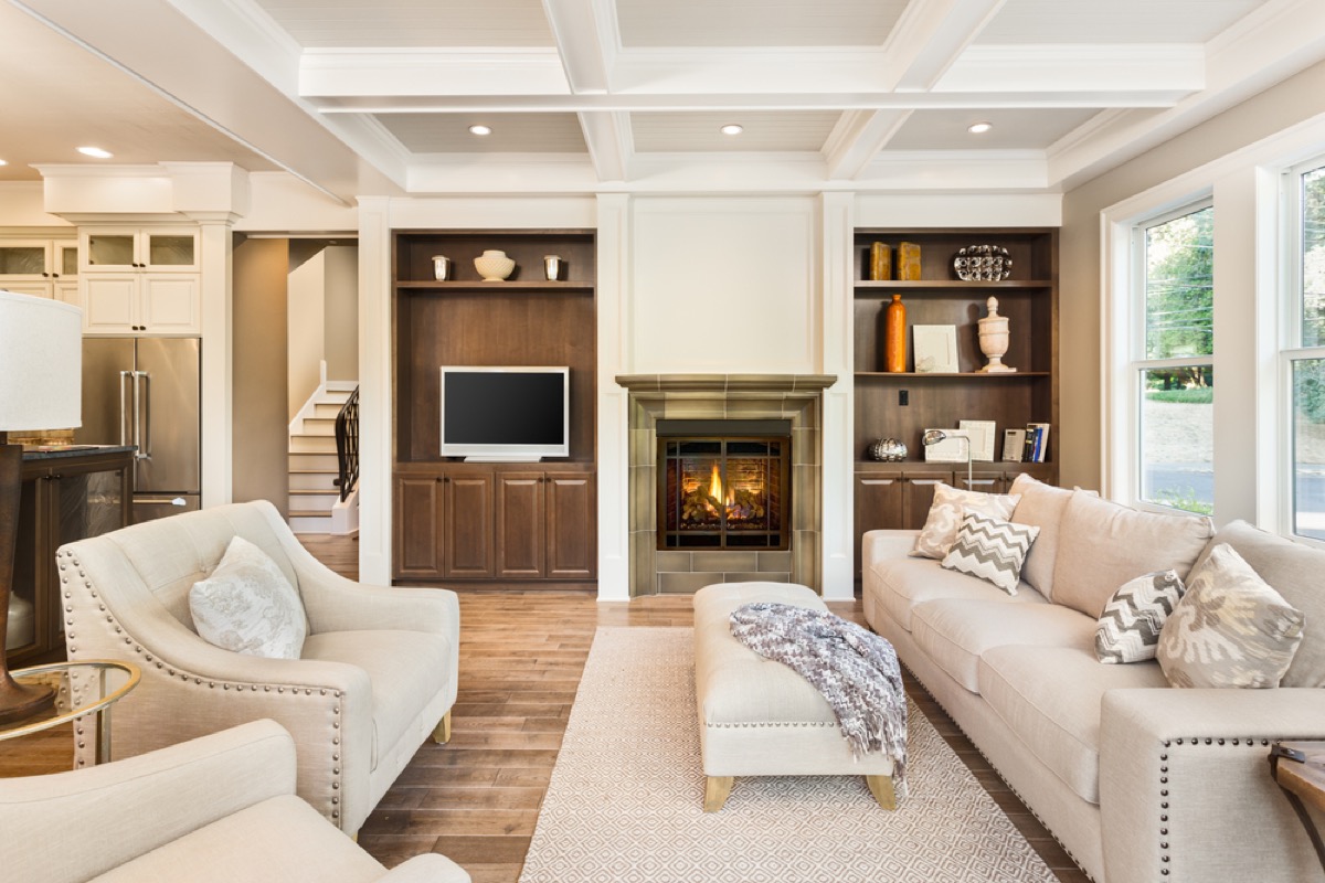 white couches and chairs facing each other in living room with fireplace