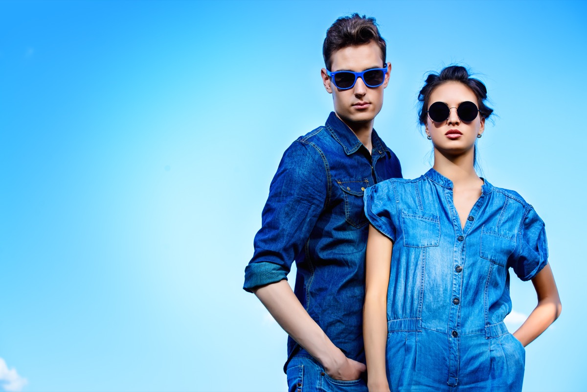 a man and woman wearing blue denim outfits against a blue background - color facts