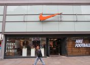 Man walks by Nike sports fashion store in Manchester, UK. Nike brand was valued at 19 billion USD in 2014.