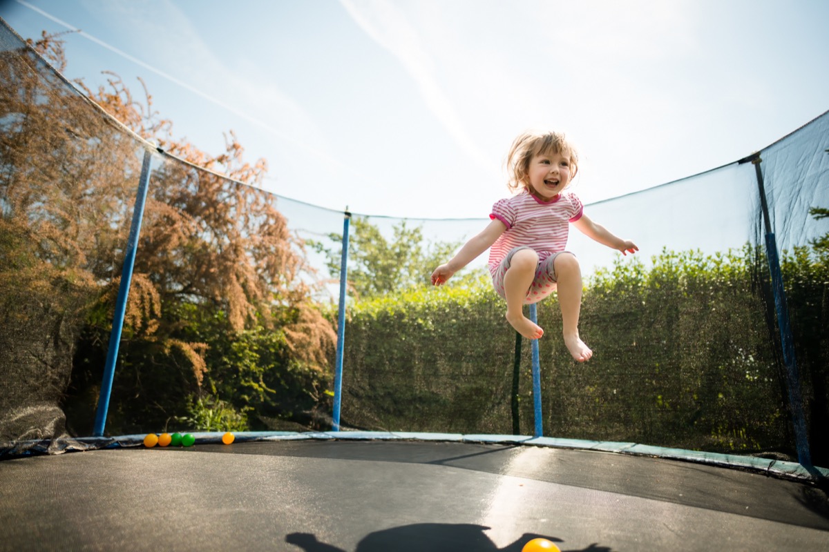 child jumping on trampoline, backyard dangers