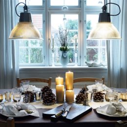 Dinner table ready for christmas dinner with pinecones and candles