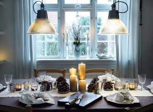 Dinner table ready for christmas dinner with pinecones and candles