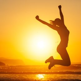 woman jumping into air on beach at sunset, monday quotes