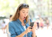 Woman on phone surprised reading viral dating story