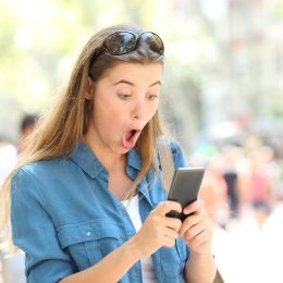 Woman on phone surprised reading viral dating story