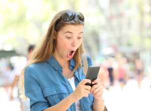 Woman on phone surprised reading viral dating story