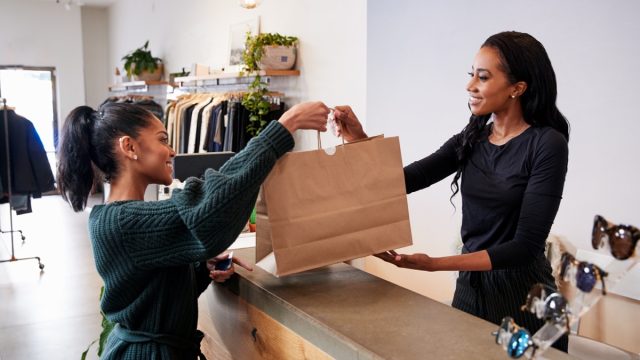 Woman shopping at checking out at the store with a cashier
