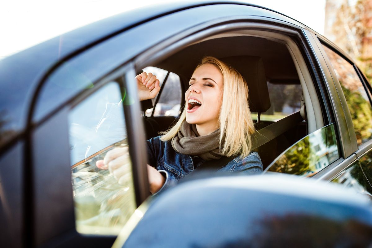 Woman singing in car, stay at home mom