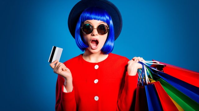 woman with shopping bags blue hair and a hat against a blue background