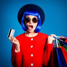 woman with shopping bags blue hair and a hat against a blue background