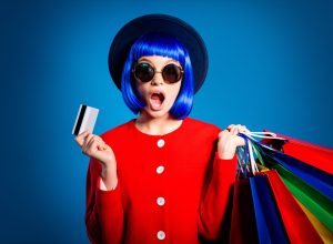 woman with shopping bags blue hair and a hat against a blue background