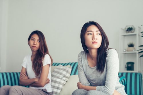 Schwules asiatisches Paar streitet und kehrt sich im Schlafzimmer den Rücken zu