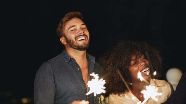 Couple celebrating New Year's Eve with sparklers outside