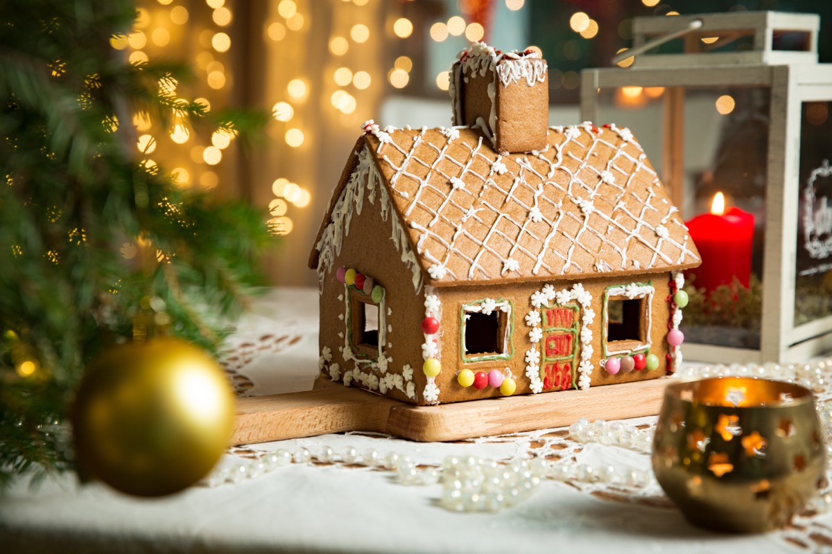 gingerbread house on table with gold ornaments