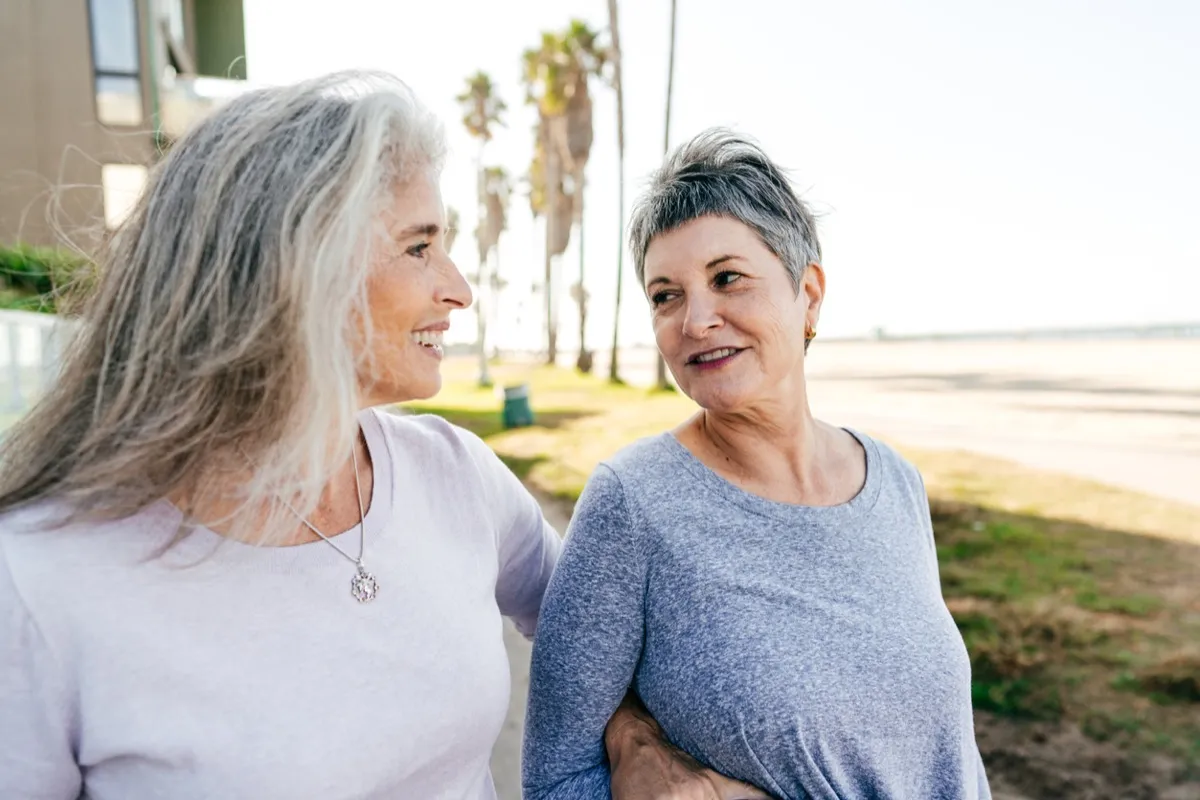 older white women couple walking and smiling outside