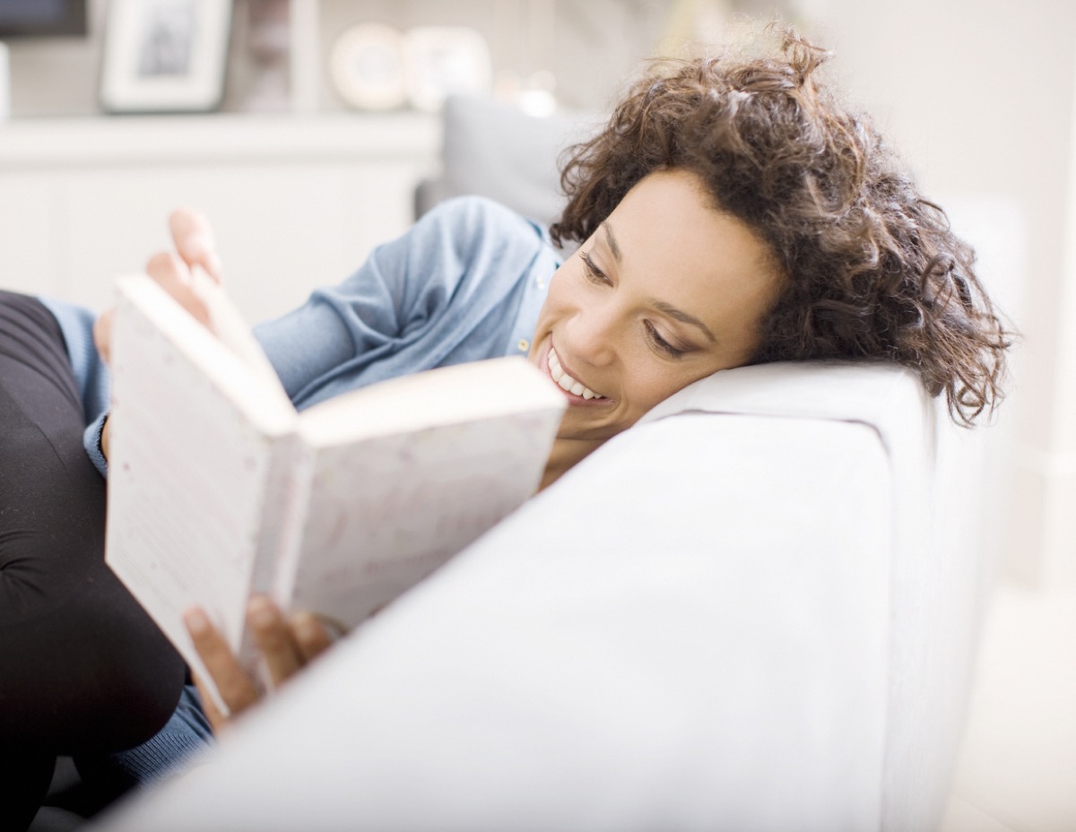 latina woman reading a book on the couch