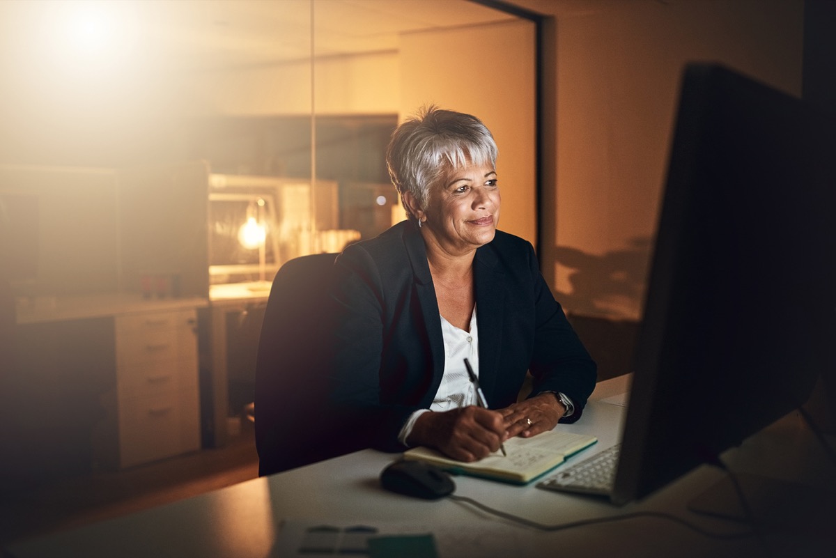 older black woman on her office computer at night