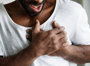 man clutching chest having heart problems