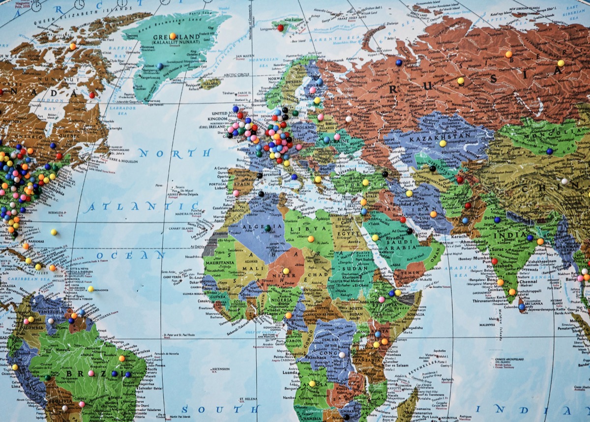 paper world map hanging on the wall with thumb tacks