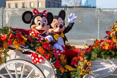 mickey mouse and minnie mouse riding in a thanksgiving parade float together