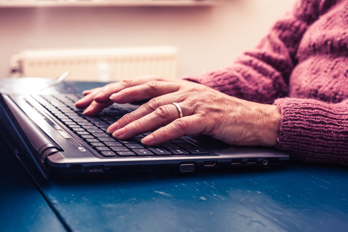 Older woman typing on laptop