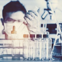 scientist with test tubes in a lab about to make a major breakthrough