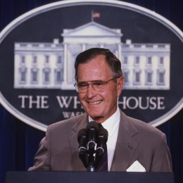 george h.w. bush tands at the podium as he responds to reporters questions during a news conference in the press briefing room at the White House in 1990.