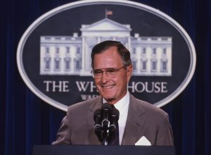 george h.w. bush tands at the podium as he responds to reporters questions during a news conference in the press briefing room at the White House in 1990.
