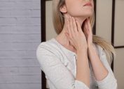 Woman Touching Her Thyroid Glands {Thyroid Problems}