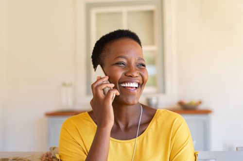 woman laughing and calling someone on the phone