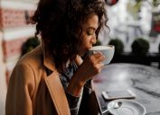 Black woman drinking a latte in a coffee shop in the winter
