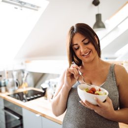 pregnant woman eating healthy food at home