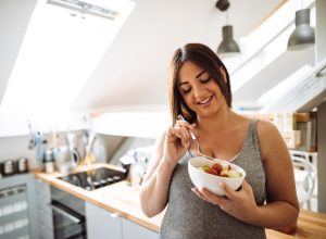 pregnant woman eating healthy food at home