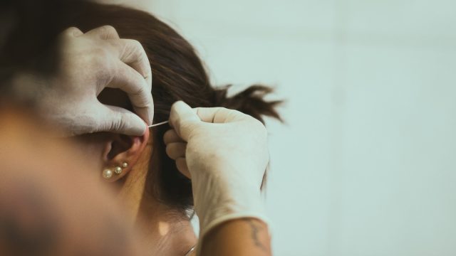 woman getting her ear pierced
