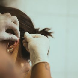 woman getting her ear pierced