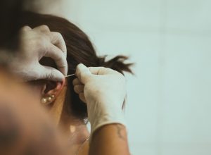 woman getting her ear pierced