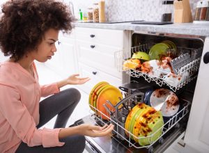 African American woman with a broken dishwasher