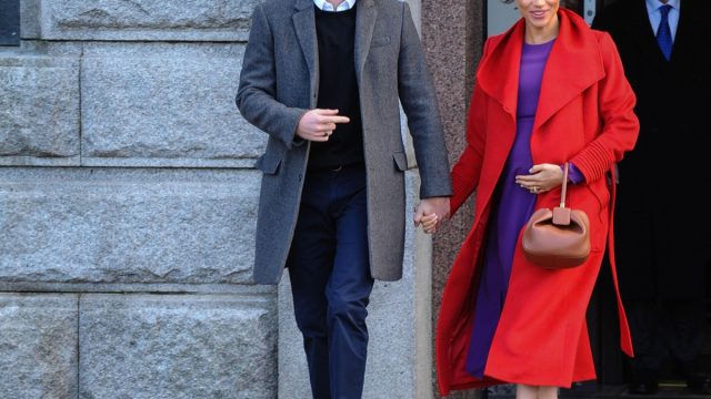 prince harry looking concerned while holding hands with meghan markle