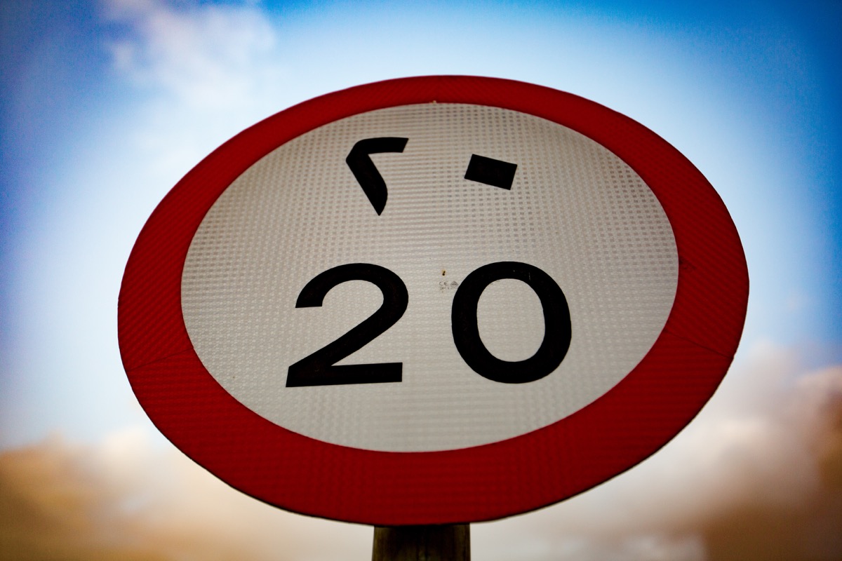 Speed limit sign with Eastern Arabic and Western Arabic numerals with cloudy sky background