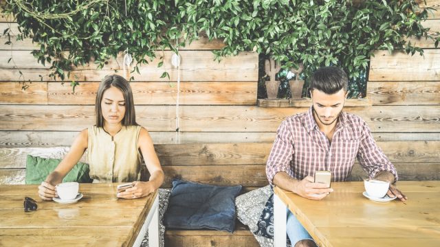 a couple using phones in a coffee shop