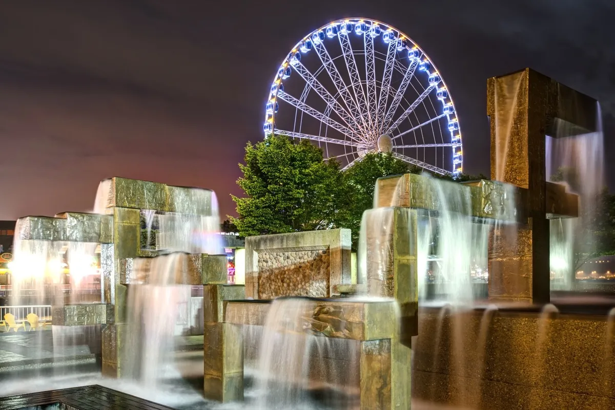 Vibrant Lights Illuminate Modern Fountain Sculpture in Night Scene with Seattle Great Wheel in Seattle, Washington