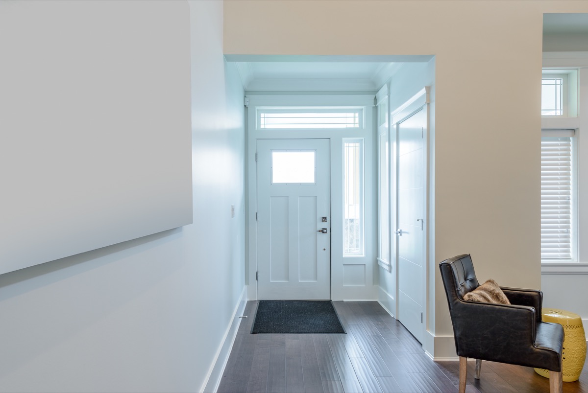 House interior. Entrance hallway with white door and hardwood floor. 