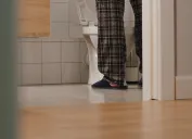man's legs in pajamas while he pees in a toilet
