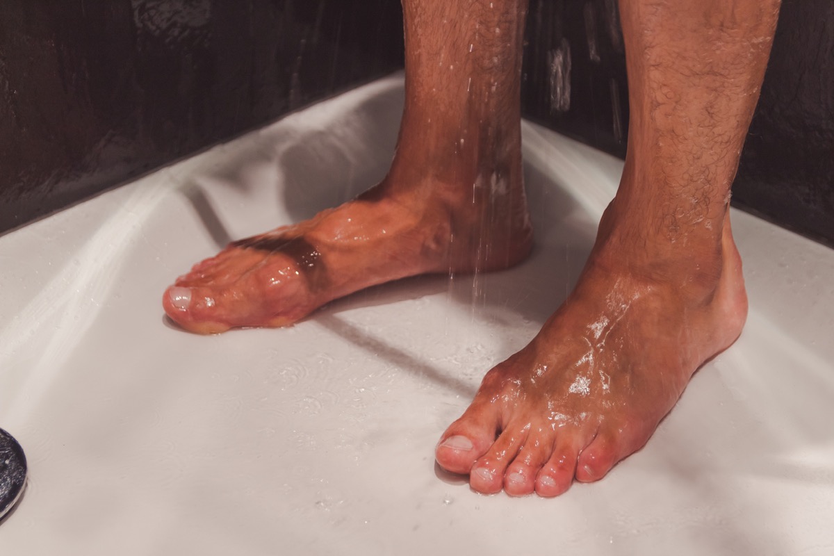 close up of white man's feet in the shower