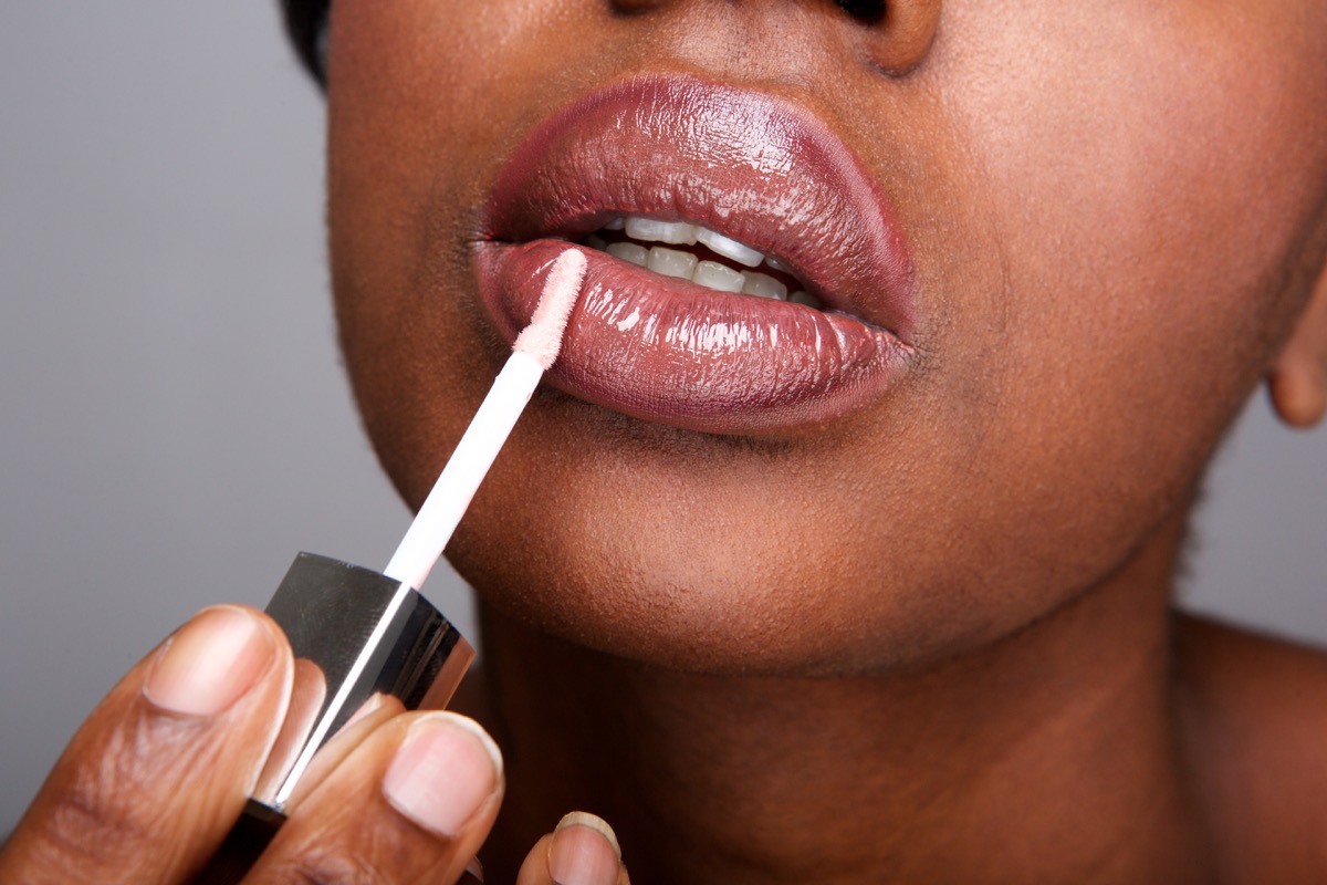 Woman applying lip gloss clouse up