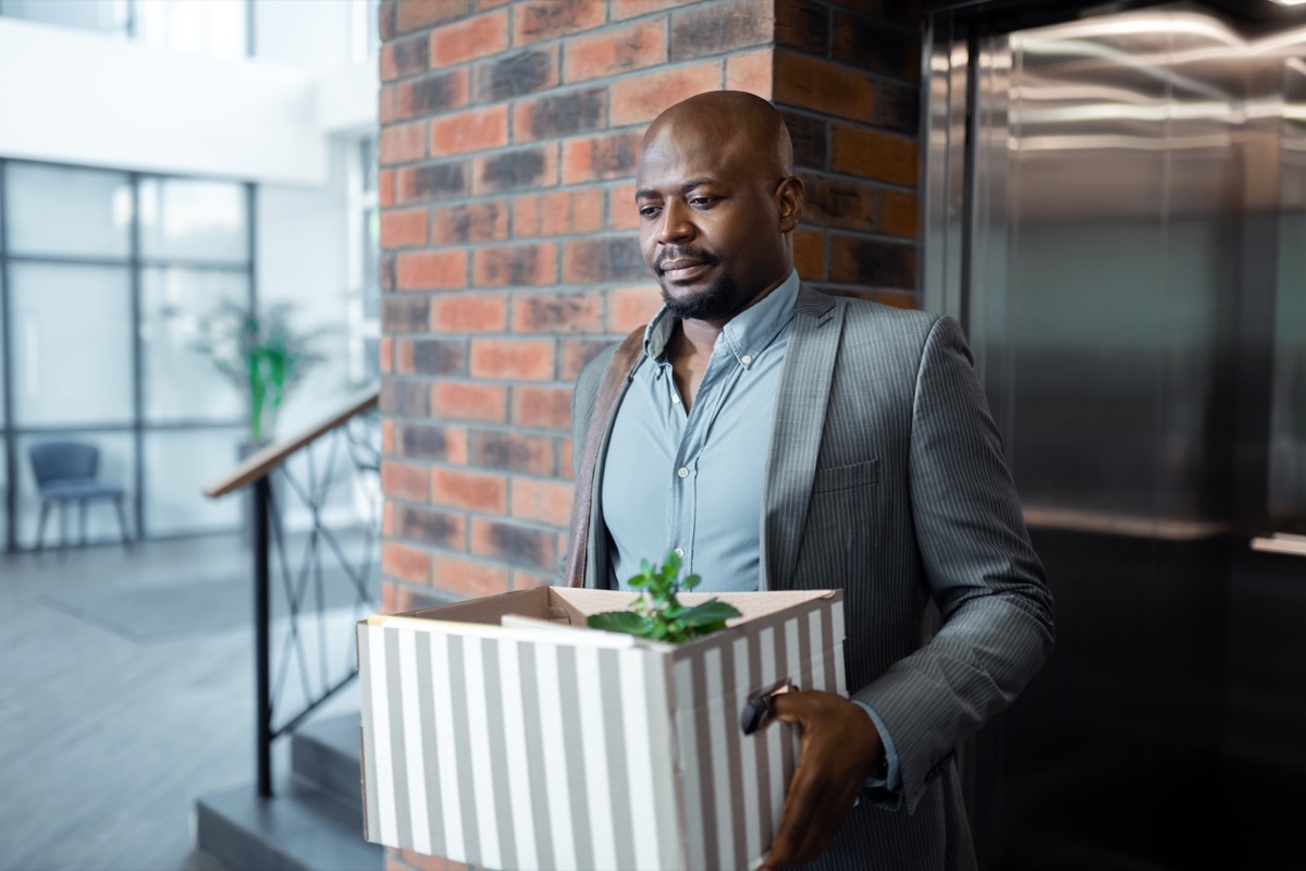 man leaving work with box after quitting job