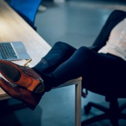 man kicking his feet up on a desk and sleeping in the office