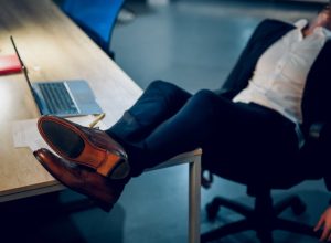 man kicking his feet up on a desk and sleeping in the office